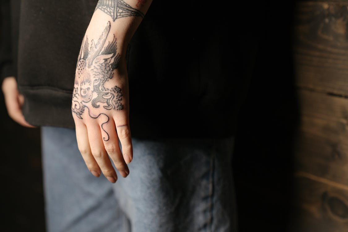 tatuaje fine line rosa en la mano