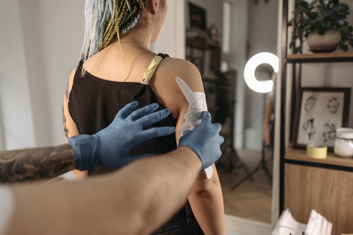tatuador aplicando stencil en el brazo del cliente