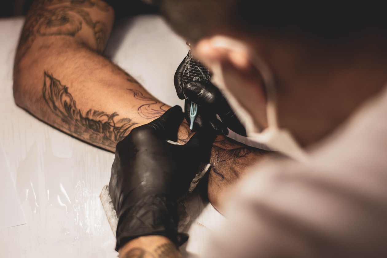 tatuaje en proceso artista trabajando en brazo cliente