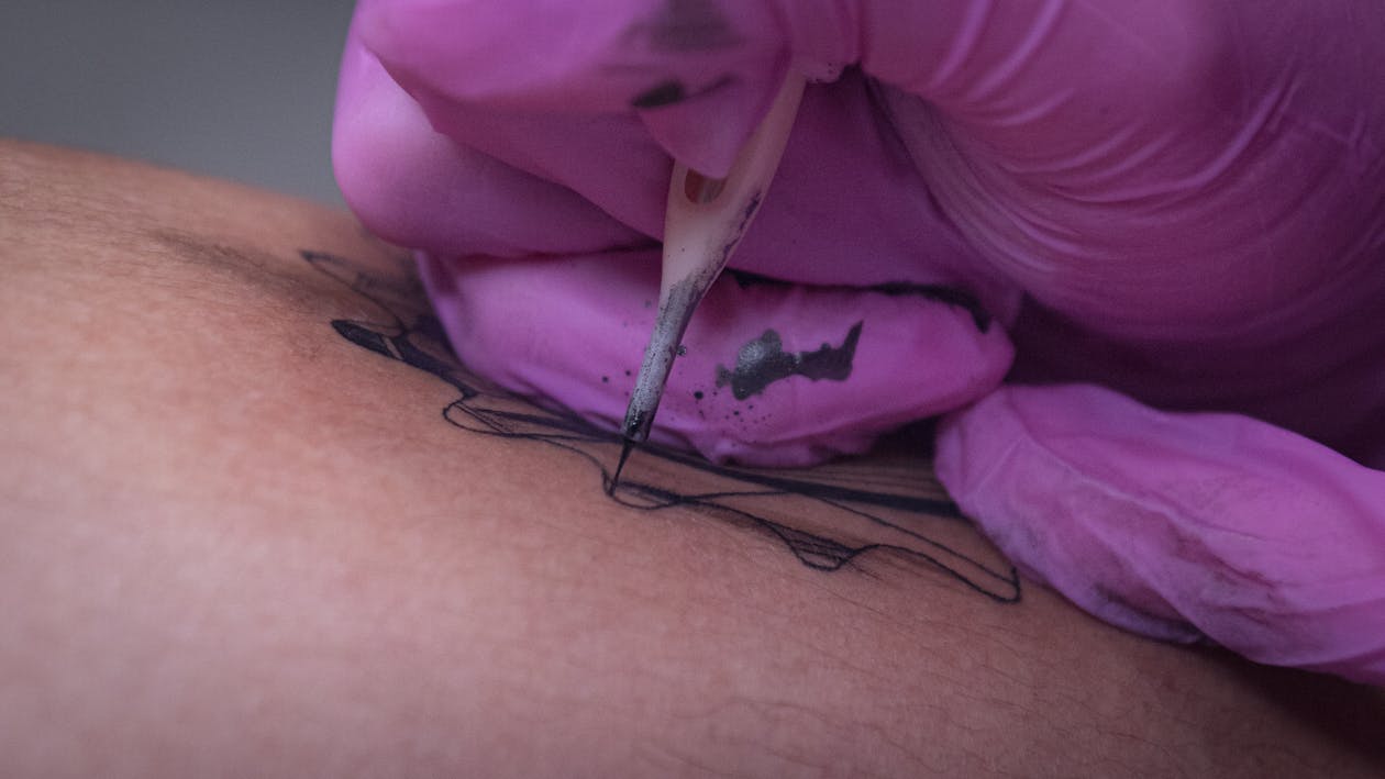 sesión de tatuaje artista tatuando diseño en la piel